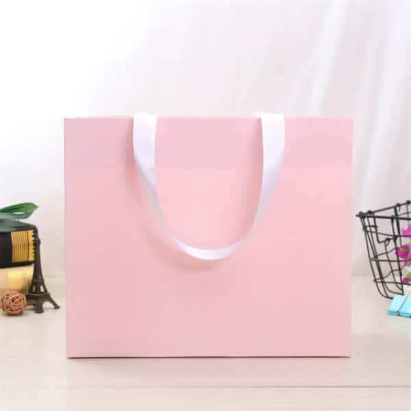 afficher le devant du sac en papier cadeau rose personnalisé