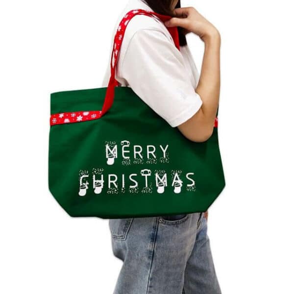 една жена носи една зелена платнена божиќна торба на рамо