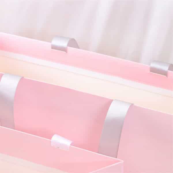 muestra el detalle del asa de la bolsa de papel de regalo rosa personalizada