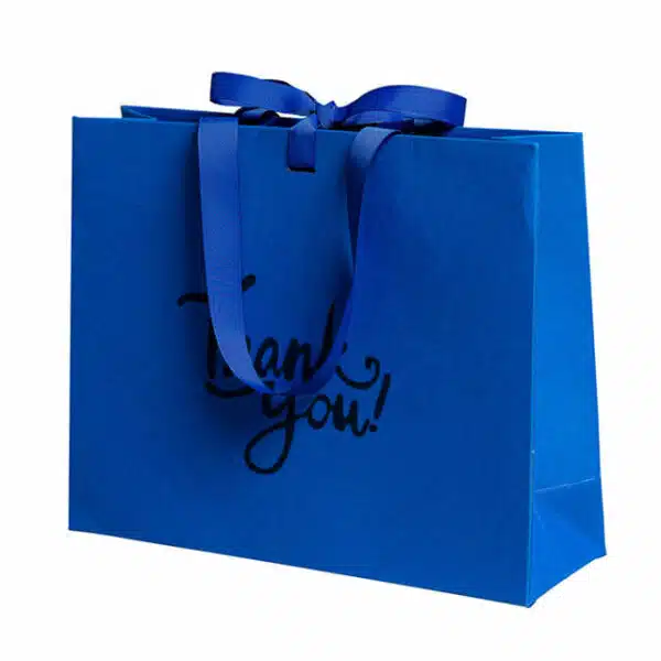 display one Klein blue custom solid color gift bag with ribbon bow