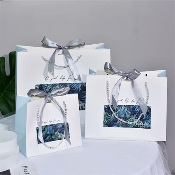 display three custom colorful gift paper bags with ribbon bow in different sizes