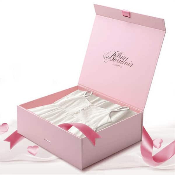 Muestre la caja de regalo rosa personalizada con tapa abatible con cierre de cinta con un vestido en el interior