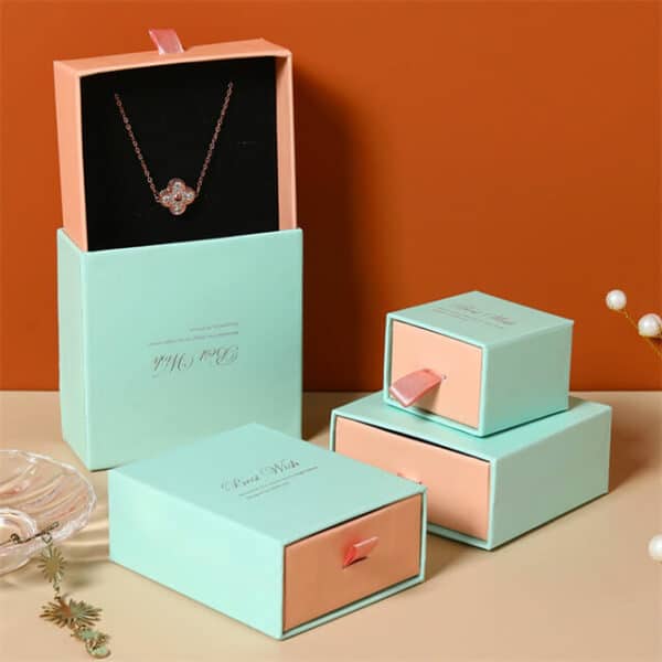 izložite hrpu plavih i ružičastih prilagođenih kutija s ladicama za nakit s otisnutim logotipom u različitim veličinama