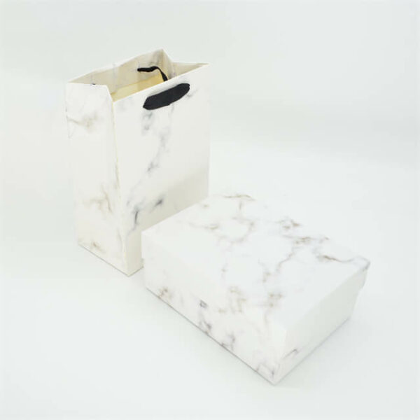 muestra una tapa personalizada y una caja rígida de base para cosméticos con la misma bolsa de papel personalizada de perspectiva