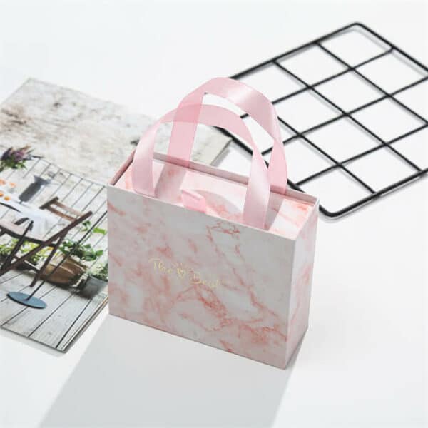 mostrar una caja rígida de cajón deslizante de regalo de ropa de lujo personalizada rosa desde el ángulo de vista