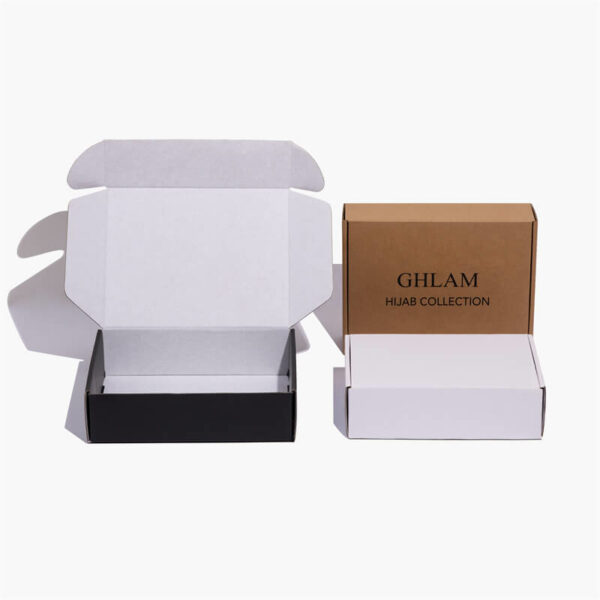 три прилагодени стандардни поштенски кутии се уметнички поставени во различни пози, една е бела, една е крафт, една е црна