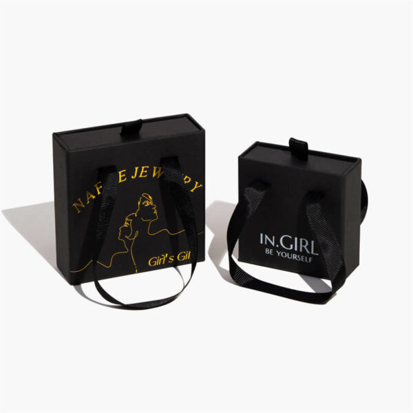 dvije crne prilagođene krute kutije za nakit s ručkama, jedna ima logo od zlatne folije, a jedna logo od bijele folije