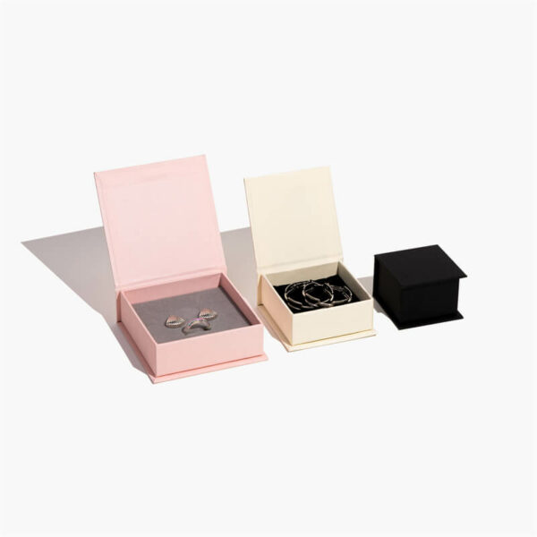 three different size custom magnetic jewelry boxes stand side by side, the pink and white are open, the black is close