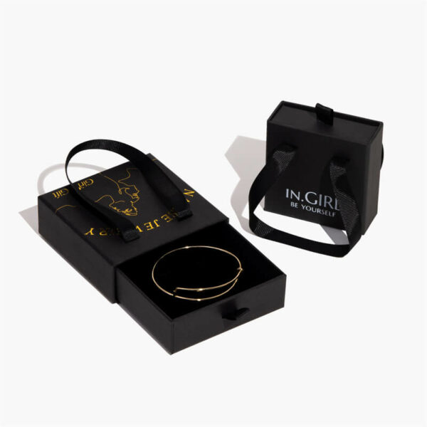dvije crne prilagođene krute kutije za nakit s ručkama, jedna je otvorena s narukvicom unutra, druga stoji desno od nje