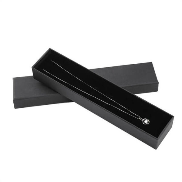 Parādiet vienu melnu pielāgotu kaklarotas dāvanu kastīti ar vāku atvērtā stāvoklī ar kaklarotu iekšpusē