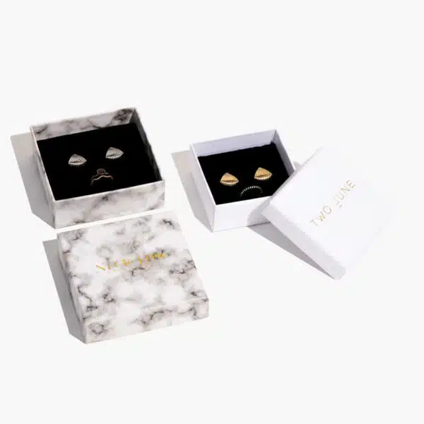 one opened premium custom jewelry box with lid lay down with a white one side by side with jewelry inside