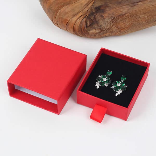 parodyti raudoną tinkintą kartoninę auskarų stalčių dėžutę su pora auskarų viduje
