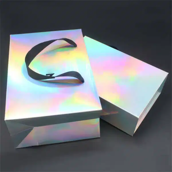 prikazati jednu prilagođenu holografsku papirnatu vrećicu s vrpčastim ručkama i krutu kutiju dizajniranu s istim izgledom
