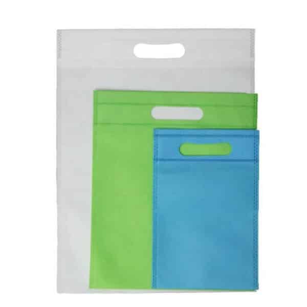 display three custom d cut non woven bags in different colours and sizes