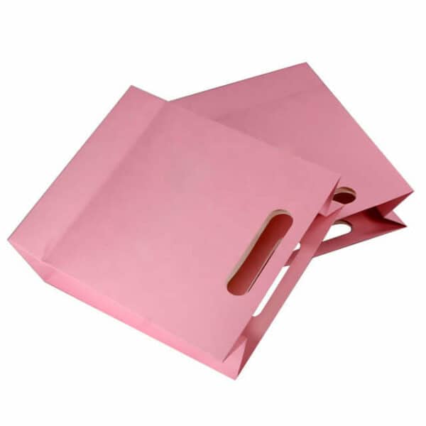 display two custom pink paper bag with die-cut handles lay down together