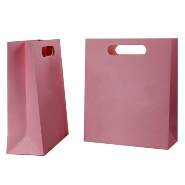 display the side and front of the custom pink paper bag with die-cut handles