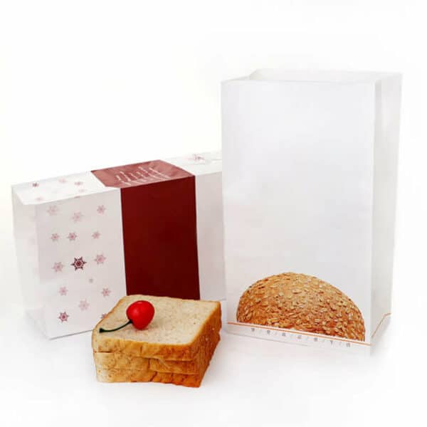 прикажете две празни прилагодени хартиени кесички СОС за пакување леб со неколку ливчиња леб и цреша покрај