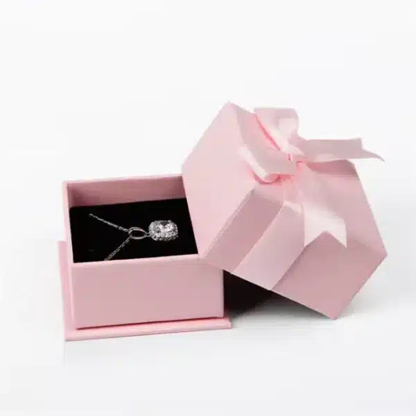 izložite jednu ružičastu krutu kutiju za nakit s poklopcem u otvorenom stanju s ogrlicom unutra