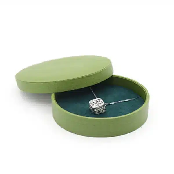 една обична тркалезна кутија за подарок со капак за накит со ланче внатре