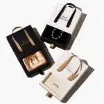 ელეგანტური შავ-თეთრი მორგებული მუყაოს უჯრის სამკაულების ყუთები სახელურით, გამოფენილი სამკაულები.