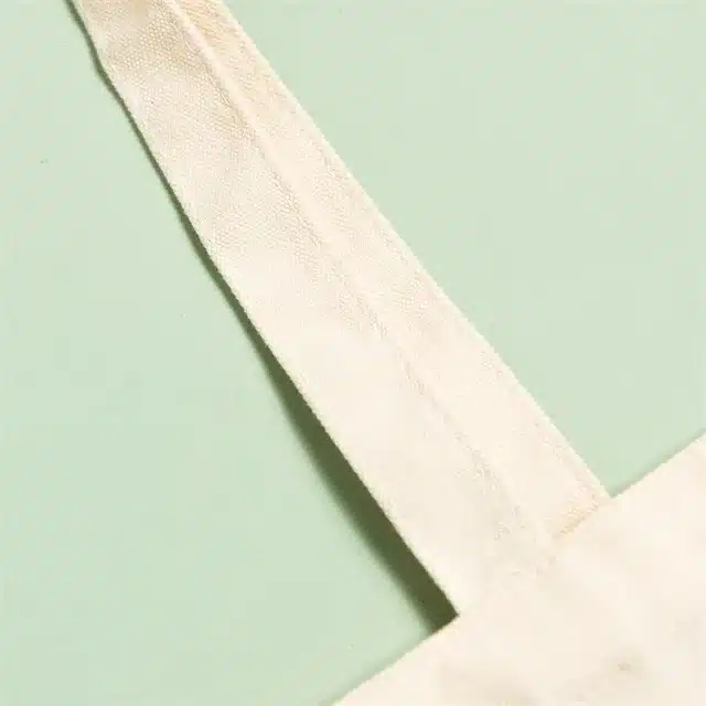 C3 Zeigen Sie das Griffdetail einer individuell bedruckten Canvas-Tragetasche im Economy-Stil in Elfenbeinfarbe an