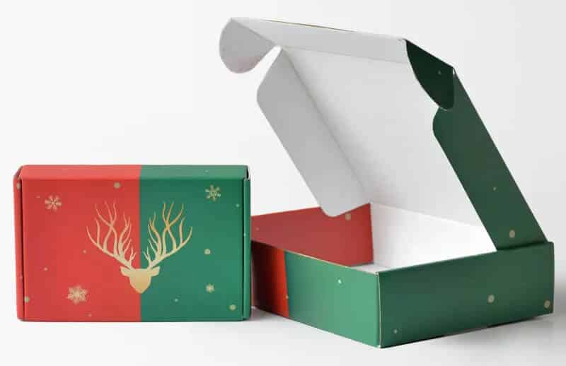two red and green mailer boxes with reindeer and snow pattern printed on them