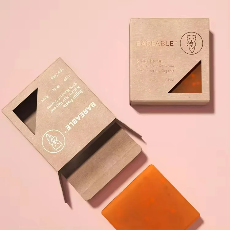 Eco-friendly custom soap packaging of one brand soap, with a cardboard box partially open revealing an orange-colored soap bar inside.