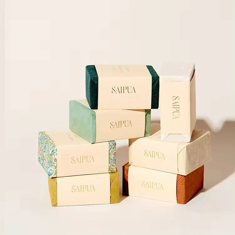Uma coleção de sabonetes artesanais de marca, cuidadosamente empilhados e expostos, apresentando embalagens elegantes e minimalistas personalizadas com um padrão floral em um dos itens.