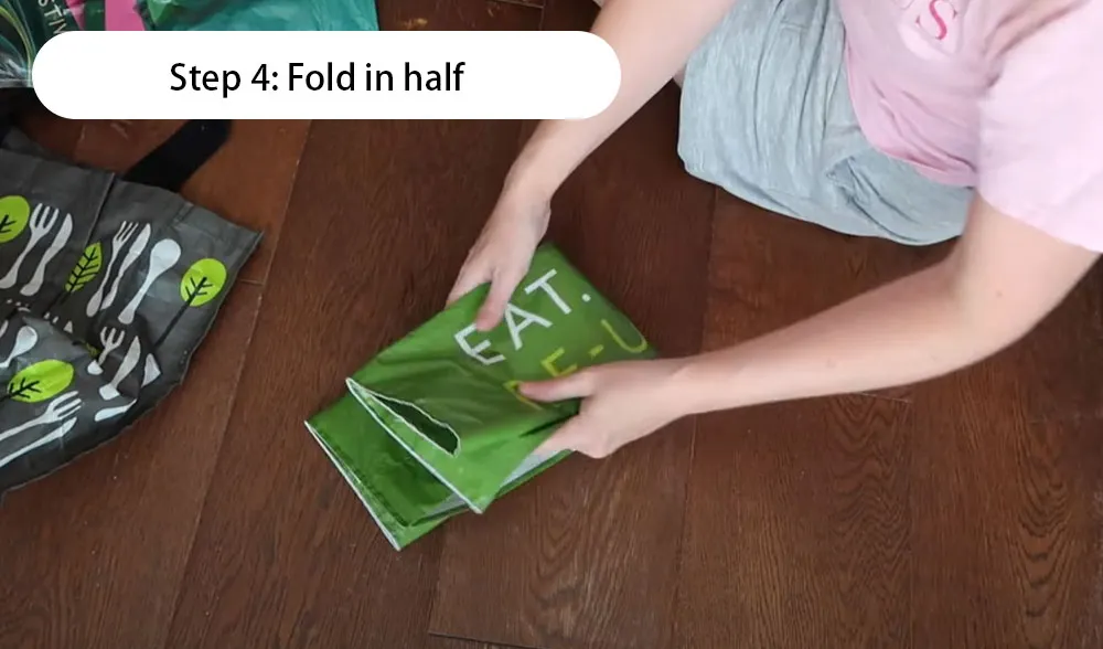 როგორ დავკეცოთ მრავალჯერადი გამოყენების ჩანთა ეტაპობრივად ილუსტრაცია: ნაბიჯი 4 გადაკეცეთ შუაზე