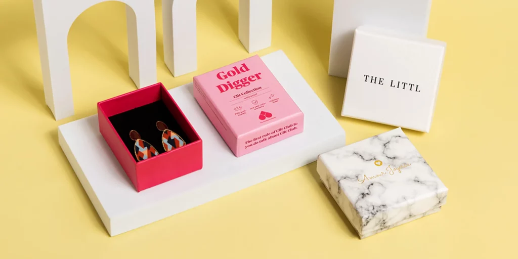 Es gibt mehrere individuell gestaltete Schmuckkästchen mit unterschiedlichen Designs vor dem gelben Hintergrund.