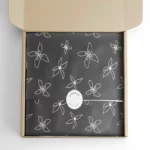 აჩვენეთ შავი დიზაინის საბაჟო საჩუქრის ქაღალდი, შეფუთული ერთი ნივთი, დალუქული ერთი სტიკერით საფოსტო ყუთში