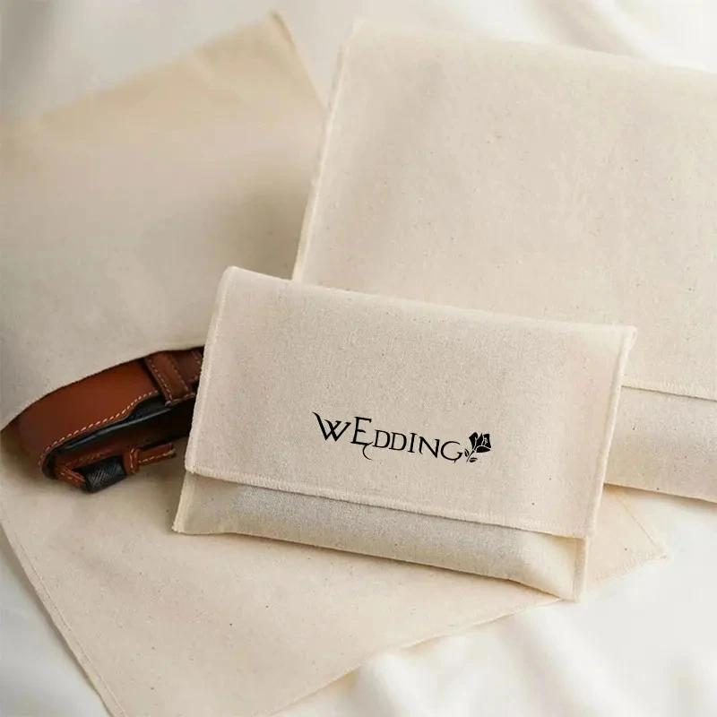 Zeigen Sie drei verschiedene Größen Custom Cotton Canva Umschlag Staubbeutel, und eine Tasche hat ein kleines Geschenk im Inneren