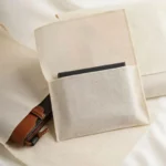 აჩვენეთ სამი განსხვავებული ბამბის ტილოს კონვერტის მტვრის ჩანთა და ორ ჩანთას აქვს პატარა საჩუქრები შიგნით