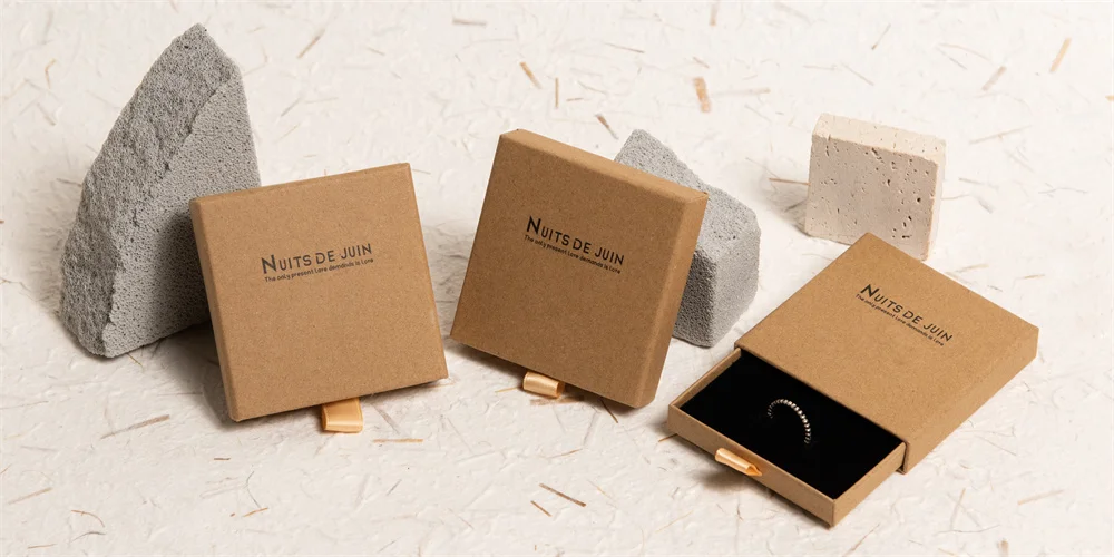 ხელს უშლის თუ არა საიუველირო ყუთები დაბინდვას? საიუველირო ნაკეთობების შენახვის საუკეთესო პრაქტიკა ბლოგის ყდა: არსებობს სამი კრაფტისგან დამზადებული საიუველირო ყუთი, ერთი იხსნება შიგნით რგოლით, დანარჩენი ორი კი დახურულია.