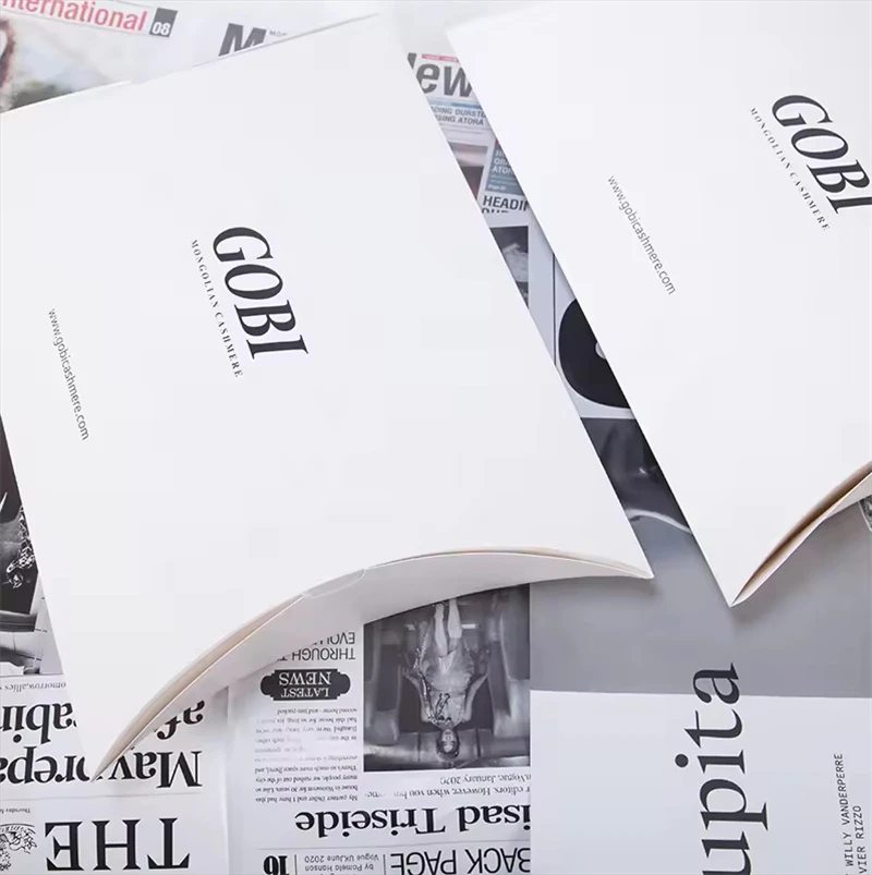 There are two white pillow boxes on the newspaper